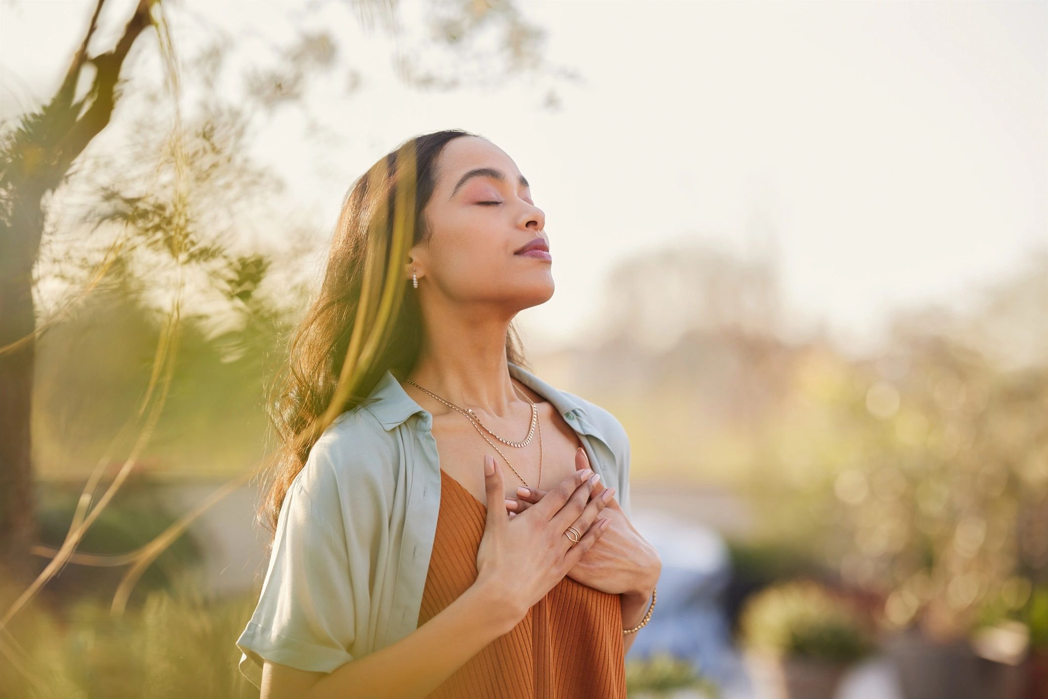 Woman practicing calming breath outdoors at sunset
