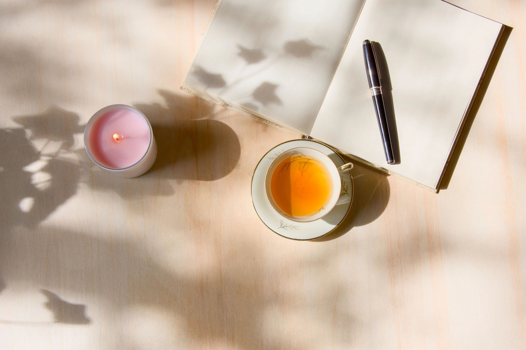Journal and tea arranged as part of a calming self-care routine