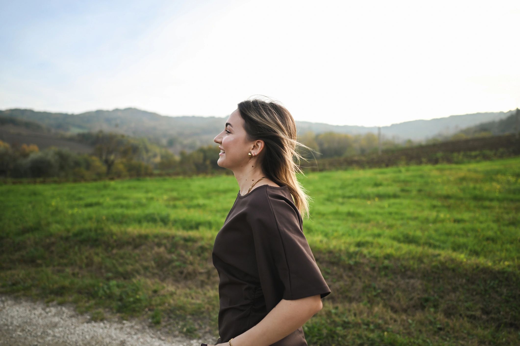 Woman outdoors in sunlight, noticing her surroundings