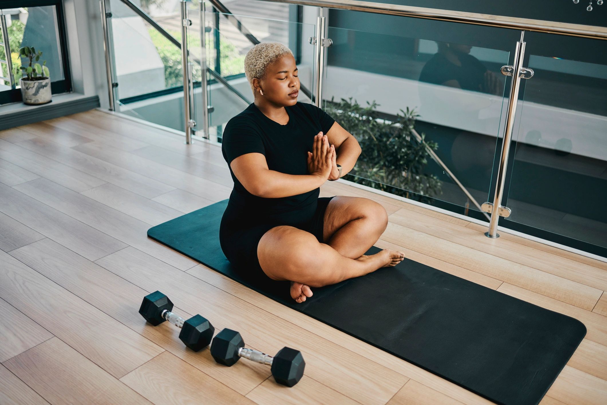 Young Black woman meditating indoors on a yoga mat